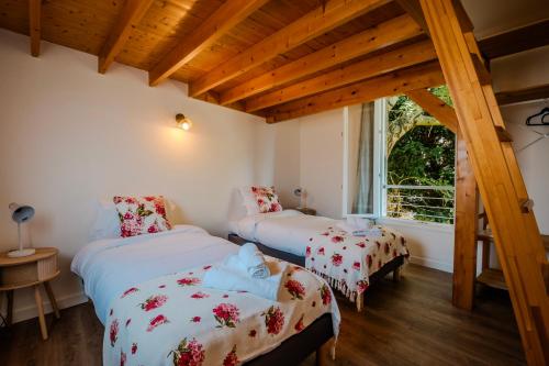 two beds in a room with wooden ceilings at Maison Segrais - 6 pers - jardin - Vaugueux - Abbaye in Caen
