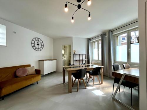 un salon avec un canapé, une table et des chaises dans l'établissement Blue Gallery #REIMS, à Reims