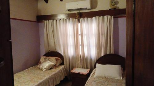 a small bedroom with two beds and a window at Rojas in Encarnación