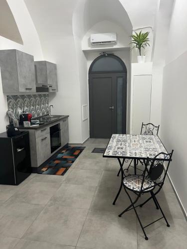 a kitchen with a table and a table and chairs at La spacca canosa in Canosa di Puglia