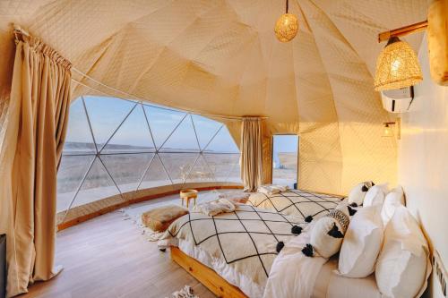 a bedroom with a bed with a view of the desert at The Orion Dome in El Karia