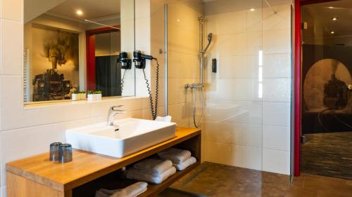 a bathroom with a sink and a shower at Altora Eisenbahn Themenhotel in Wernigerode