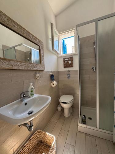 a bathroom with a sink and a toilet and a mirror at Marilù Casa Vacanza in San Vito lo Capo