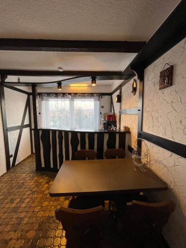a dining room with a wooden table and chairs at Am Waldrand in Attendorn