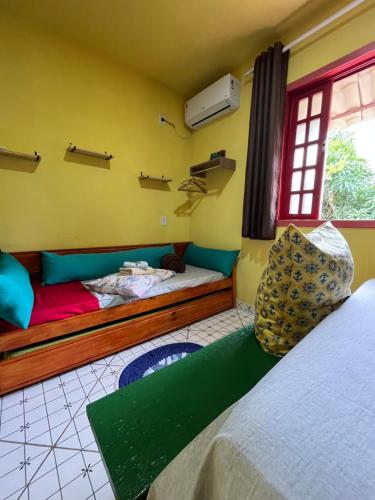 a bedroom with two beds and a window at Pousada Morango das Palmas in Praia de Palmas