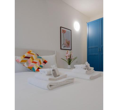 a white bedroom with two towels on a bed at Italian Experience- Aselli Home in Pavia
