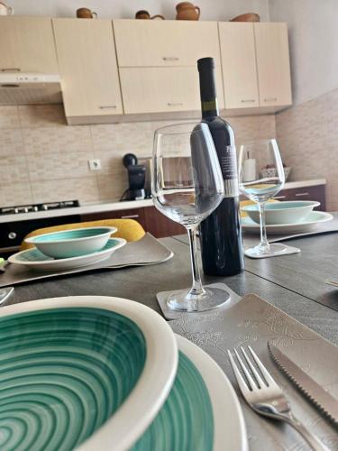 a table with two glasses and a bottle of wine at Apartmani Anna in Omišalj