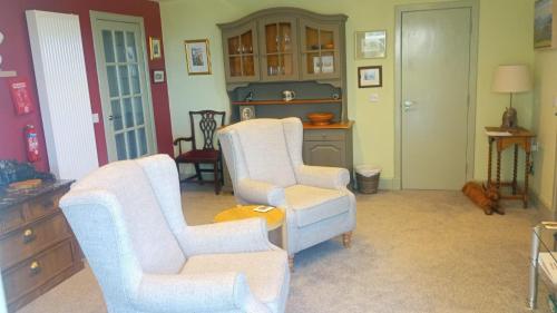 a living room with two chairs and a table at 2 Guests - Garden & Patio - Sea Views in Strathcarron