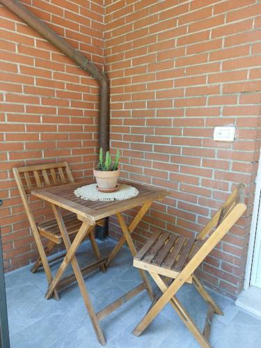 a wooden table and two chairs next to a brick wall at L'acero in La Spezia