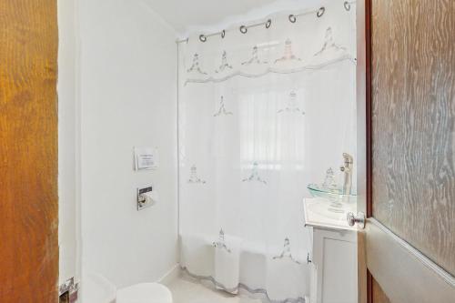 a bathroom with a shower and a toilet and a sink at Mermaid Cottage in Falmouth