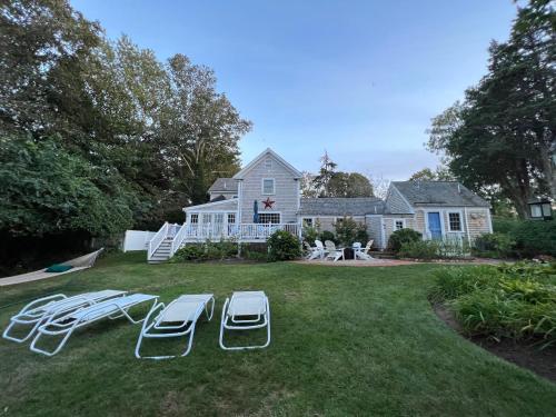 a yard with two lounge chairs and a house at Sea Meadow Inn in Brewster