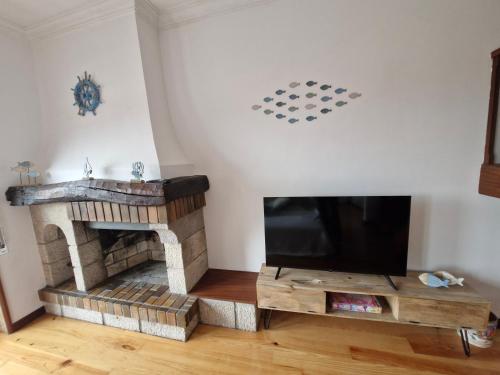 a living room with a fireplace and a flat screen tv at Vila Âncora Beach House 1 in Vila Praia de Âncora