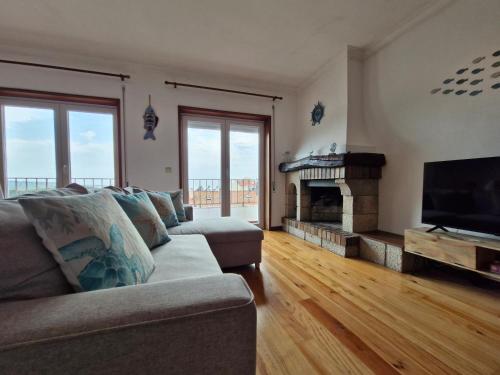 a living room with a couch and a fireplace at Vila Âncora Beach House 1 in Vila Praia de Âncora