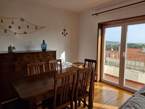 a dining room with a table and chairs and a window at Vila Âncora Beach House 1 in Vila Praia de Âncora