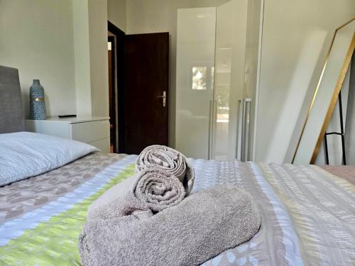 a bed with a pile of towels on it at Apartmani Anna in Omišalj
