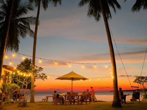 a dinner party on the beach at sunset at Sunari Beach Resort Selayar - Real in Pareangang