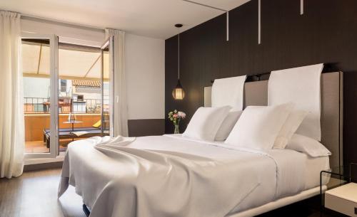 a bedroom with a large white bed and a balcony at Francisco I Boutique in Madrid