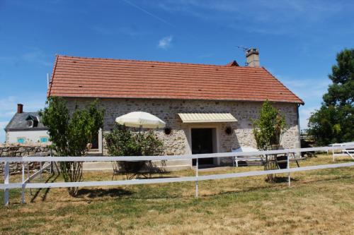 a stone house with a white fence in front of it at Maison centaure in Maisonnais