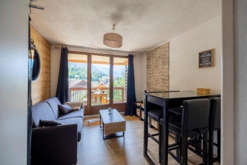 a living room with a table and a couch at Mas de Blais appartement Chaleureux à 5 minutes des pistes in Briançon