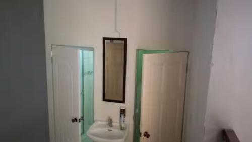a bathroom with a sink and a mirror at Le Chateau - Scarlet Ibis Apartment in Point Fortin