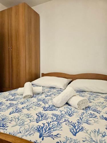 a bedroom with a bed with towels on it at Apartmani Anna in Omišalj
