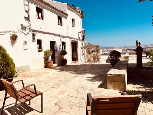 a white building with two chairs in front of it at Acogedora Casa Rural en Olvera La Morada in Olvera