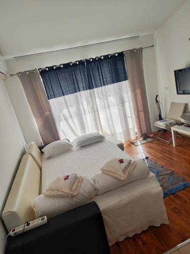 a bedroom with a large bed in front of a window at Art studio Marina Cape-private host in Ravda