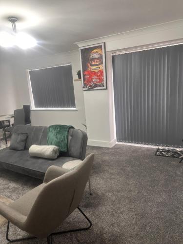 a living room with a couch and chairs and a window at Enjoy city living in this one-bedroom flat, complete with a balcony and secure parking in Birmingham city center in Birmingham