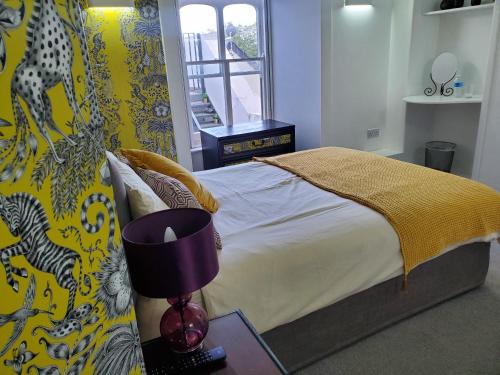 a bedroom with a bed and a table with a lamp at Peterborough House in Saint Aubin