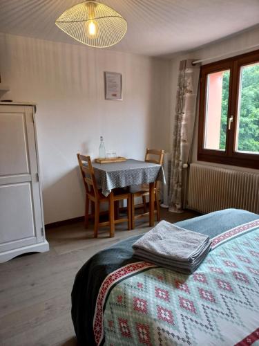 a bedroom with a table and a table and chairs at Les Sapins in Bussang