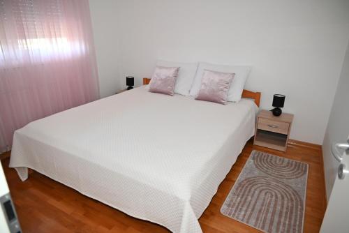 ザグレブにあるApartman As-Westのベッドルーム(ピンクの枕が付いた白いベッド付)