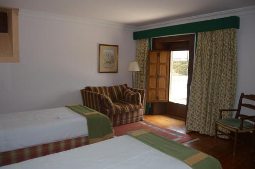a hotel room with a bed and a chair and a window at Parador de Gredos in Navarredonda de Gredos