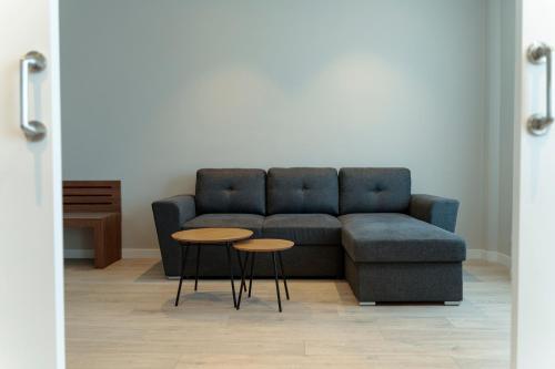 a living room with a blue couch and two tables at ARVA Santiago León in León