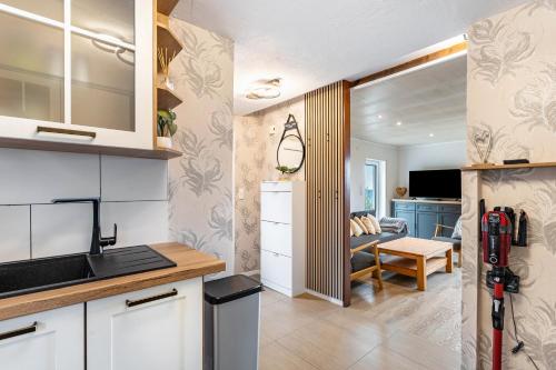 a kitchen with white cabinets and a living room at Perle am Pön in Medebach