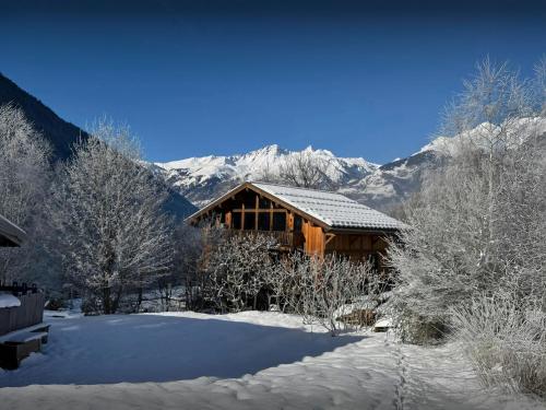 une cabane en rondins dans la neige avec des montagnes en arrière-plan dans l'établissement Chalet Wonderland - OVO Network, à Montvalezan