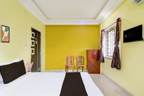 a bedroom with a bed and two chairs at Hotel O TARA in Jojera
