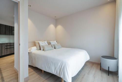 a white bedroom with a white bed with pillows at Ca Gracia Bocairent in Bocairent