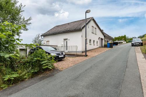 a house with a car parked on the side of a road at Perle am Pön in Medebach