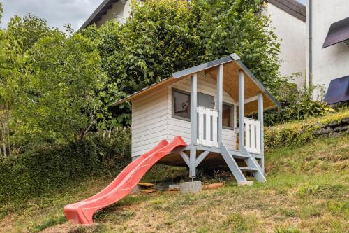 a play house with a slide in a yard at Perle am Pön in Medebach