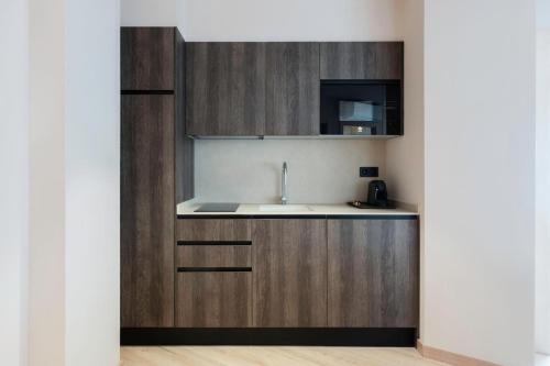 a kitchen with wooden cabinets and a sink at Ca Gracia Bocairent in Bocairent