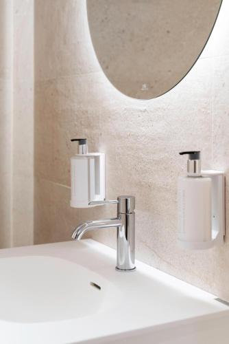 a bathroom sink with two soap dispensers on it at Ca Gracia Bocairent in Bocairent