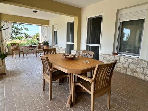 a wooden table and chairs in a living room at Comfortable Home in Epanomi