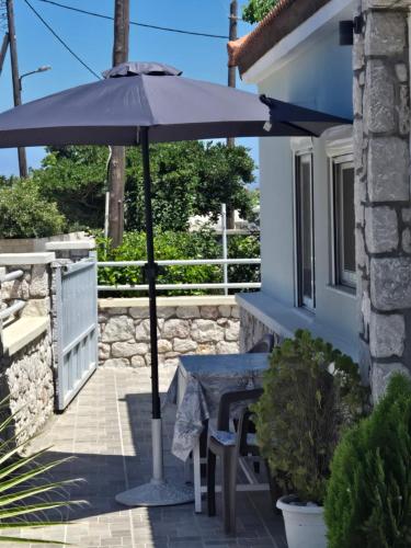 a table and an umbrella on a patio at Anastasia's garden house in Ialyssos