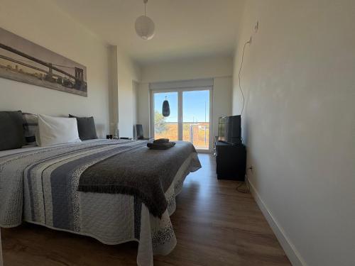 a bedroom with a bed and a large window at Modern Big Room with Balcony in New Apartment in Montijo