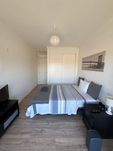 a bedroom with a bed with a blue comforter at Modern Big Room with Balcony in New Apartment in Montijo