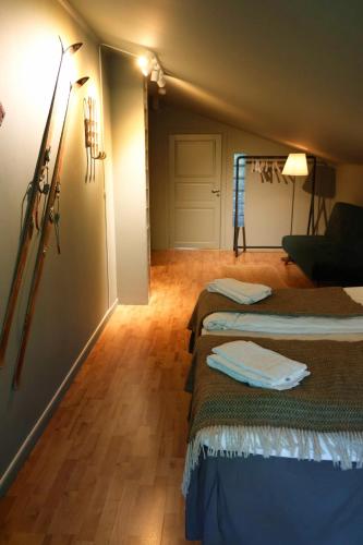 a room with two beds and a living room at Hotell Åre Fjällsätra in Undersåker