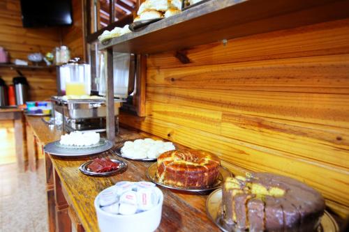 een bar met verschillende soorten gebak en gebak bij Monte Carlo Pousada in Olímpia