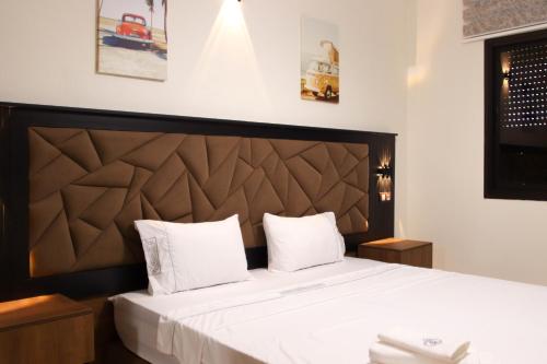 a bedroom with a large bed with white pillows at Larache haut standing in Larache
