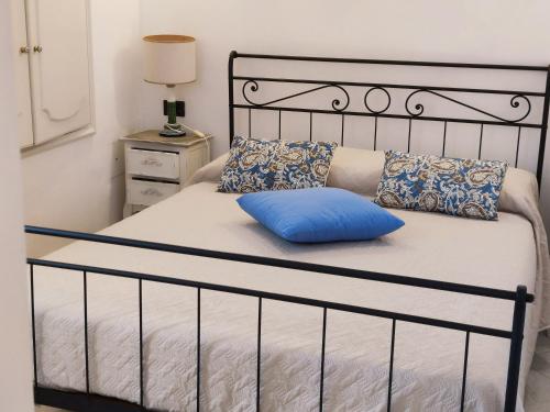 a bed with a blue pillow on top of it at Delizioso appartamento a Capri in Capri