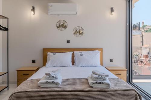 a bedroom with a bed with towels on it at La Vue, Suites For Living in Zakynthos Town